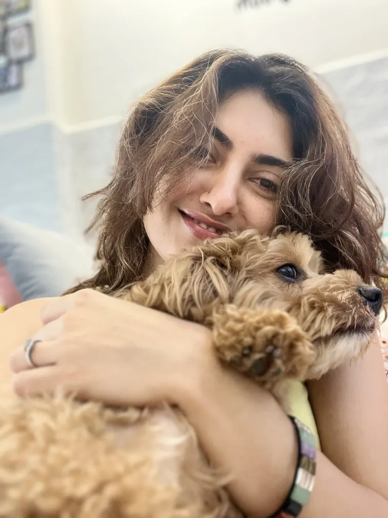 A happy pet parent hugging her dog