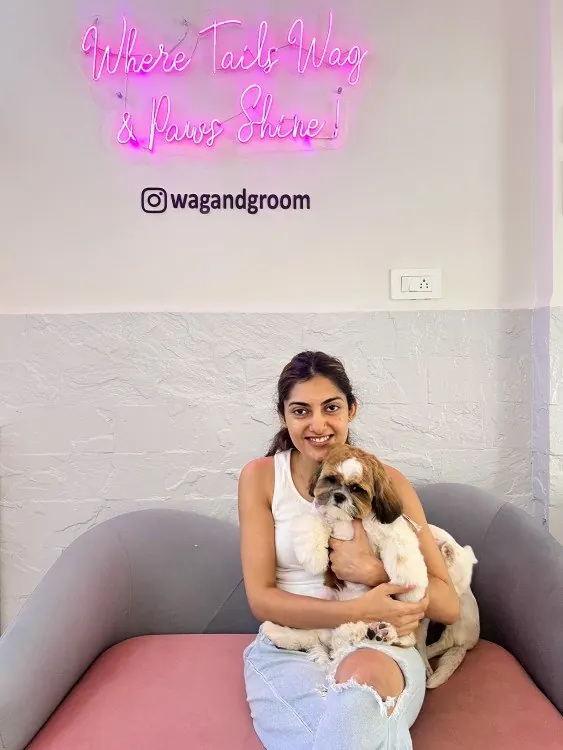 Inside the Wag & Groom salon under the "Where Tails Wag & Paws Shine" neon sign